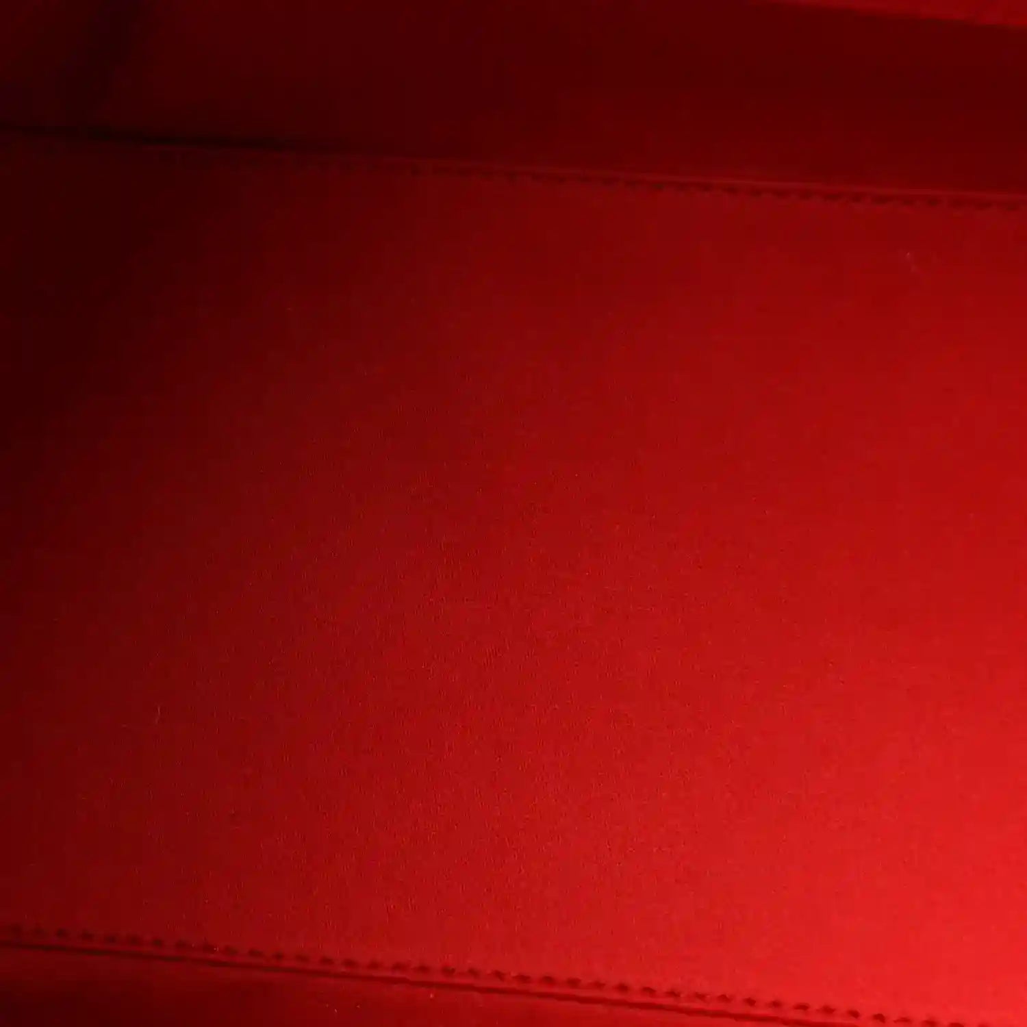 Burgundy quilted leather panel with visible stitched seam detail.