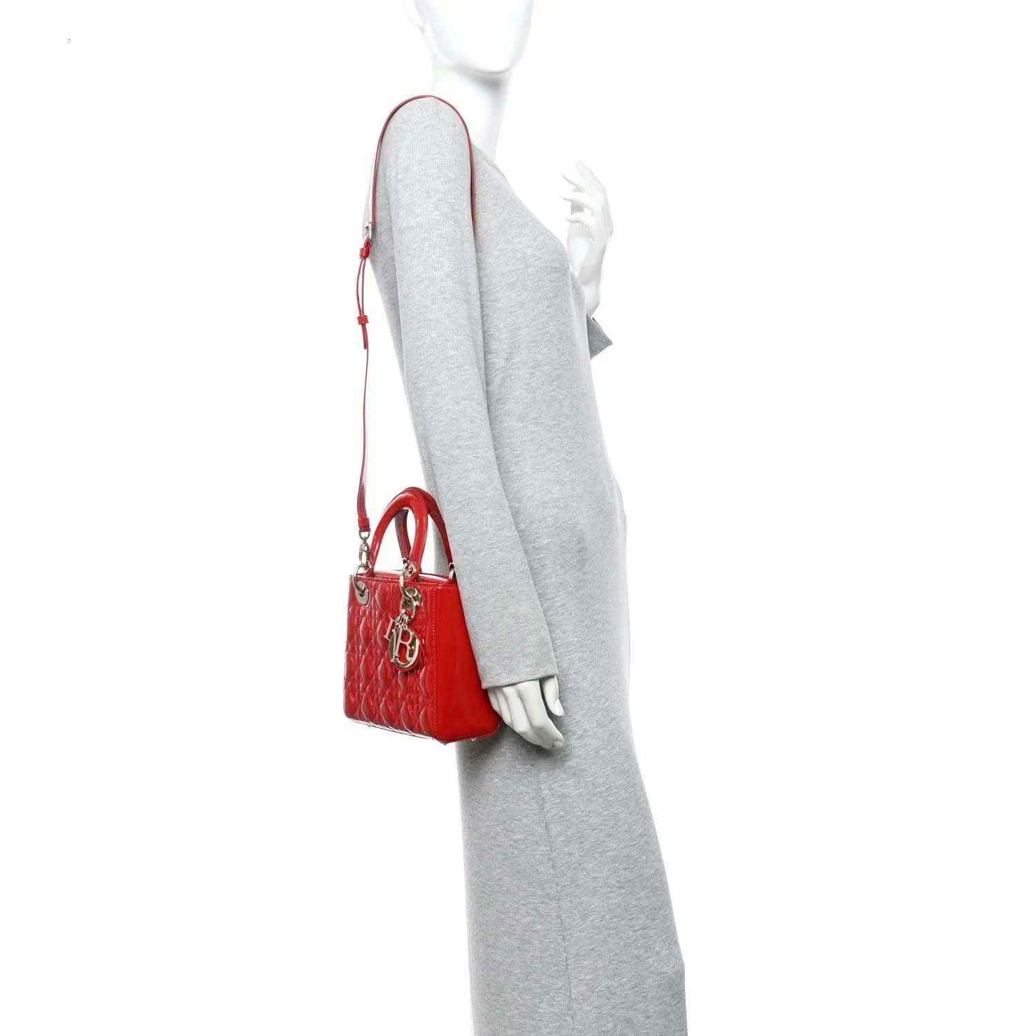 Christian Dior small red patent quilted handbag, worn on wrist strap, side view