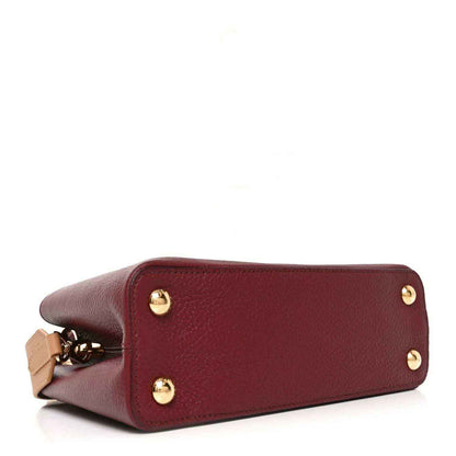 Bordeaux leather handbag base with gold studs and corner strap hardware.