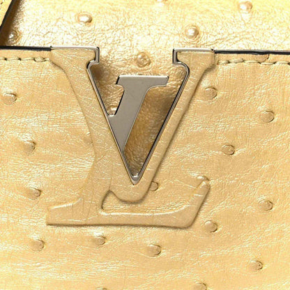 Yellow ostrich-textured mini bag with large LV metal logo on front