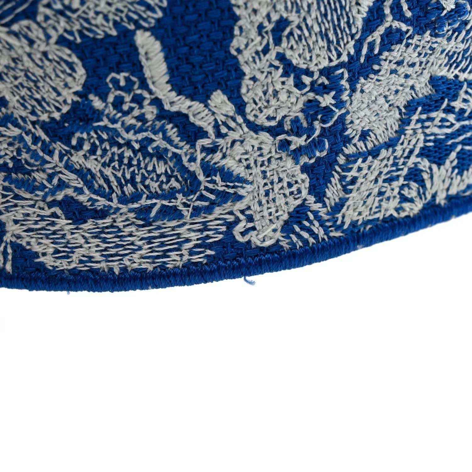 Blue-and-white toile bag hem with embroidered border, close-up