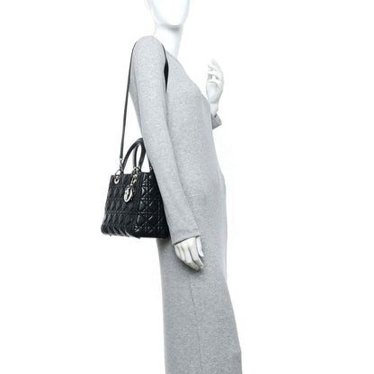 Black Lady Dior handbag worn on a mannequin with shoulder strap and quilted finish