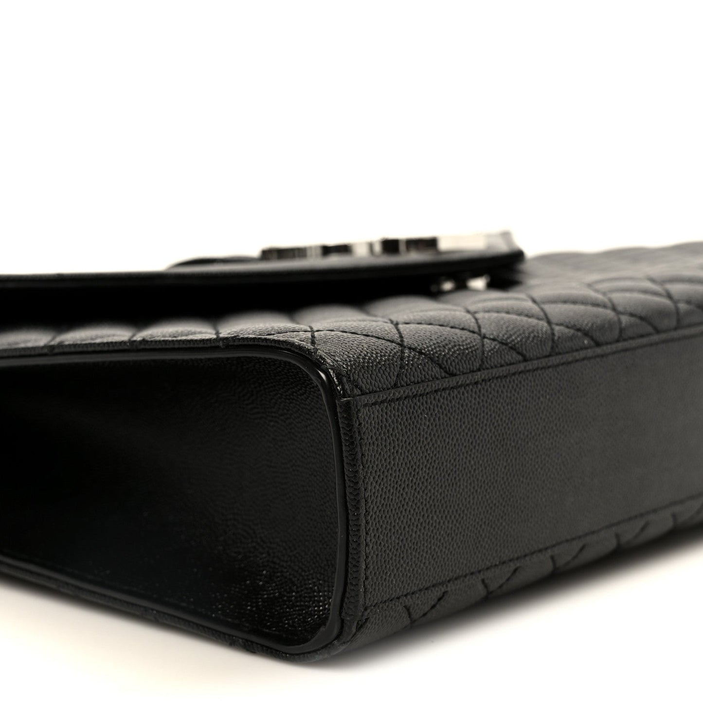 Black quilted satchel side view with top zipper seam and leather trim
