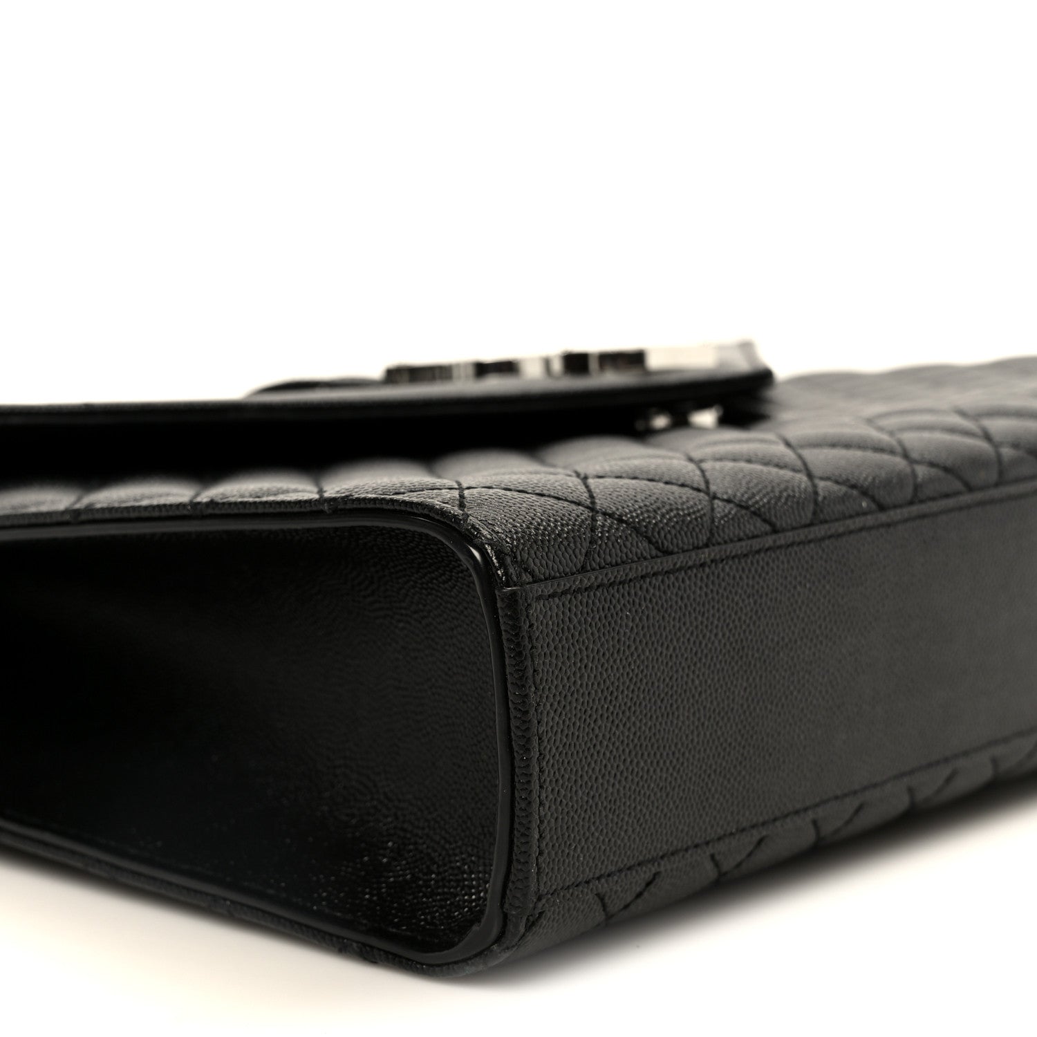 Black quilted satchel side view with top zipper seam and leather trim