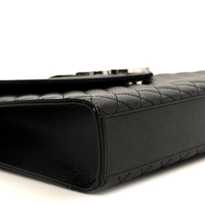 Black quilted satchel side view with top zipper seam and leather trim