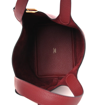 Burgundy grained leather interior with top opening and leather shoulder strap