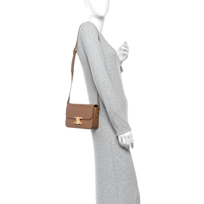 Calfskin crossbody bag on model, bronze flap with gold Triomphe clasp