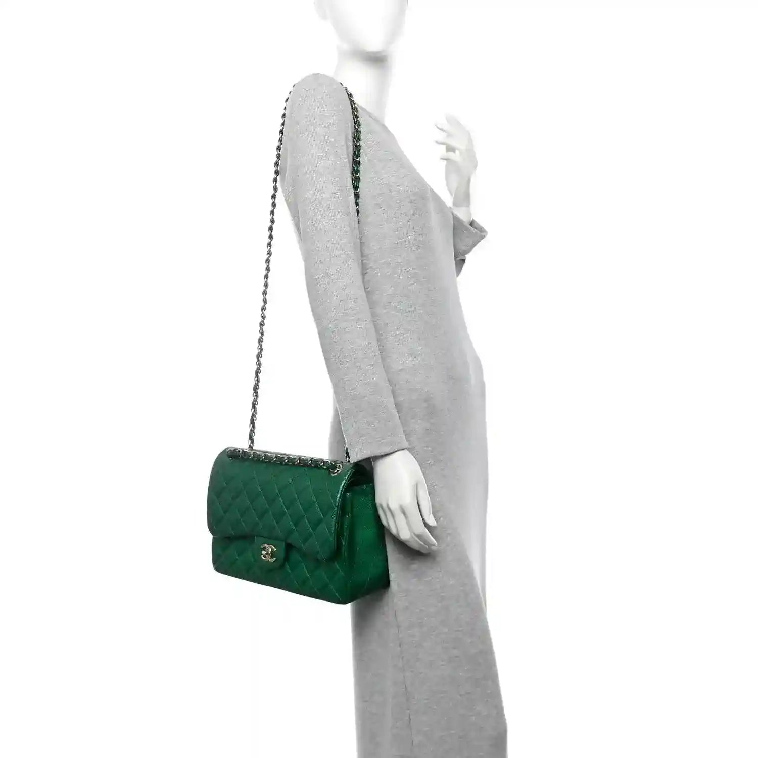 Green quilted leather shoulder bag with short chain strap worn on model’s arm.
