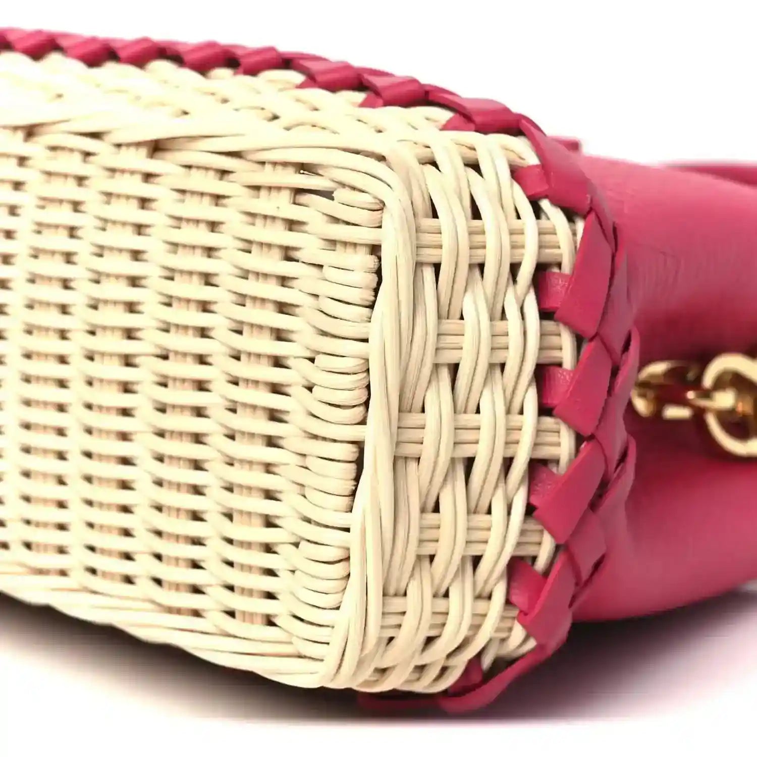 Woven rattan end section with magenta leather trim and gold hardware, close-up