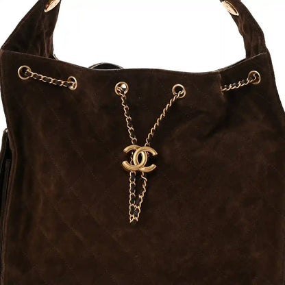 Dark brown suede quilted handbag front with CC pendant on gold chain