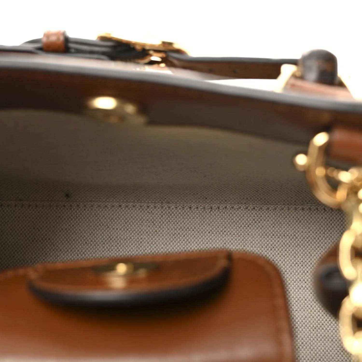 Gucci mini tote bag close-up, brown leather trim with gold hardware and bamboo handle