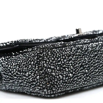 Black rhinestone small flap bag side with rounded bottom edge and zipper seam