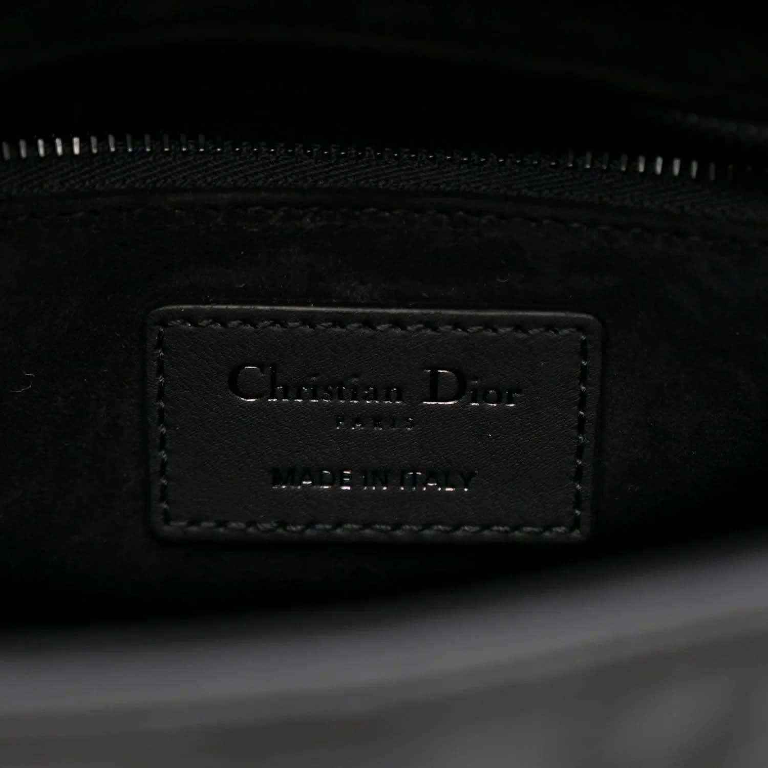 Interior label on a black Lady Dior handbag with zipper track visible