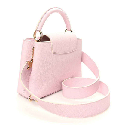 Guimauve pink leather handbag with front flap pocket, top handle, and shoulder strap