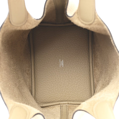 Beige leather handbag interior with fabric lining and small branding stamp