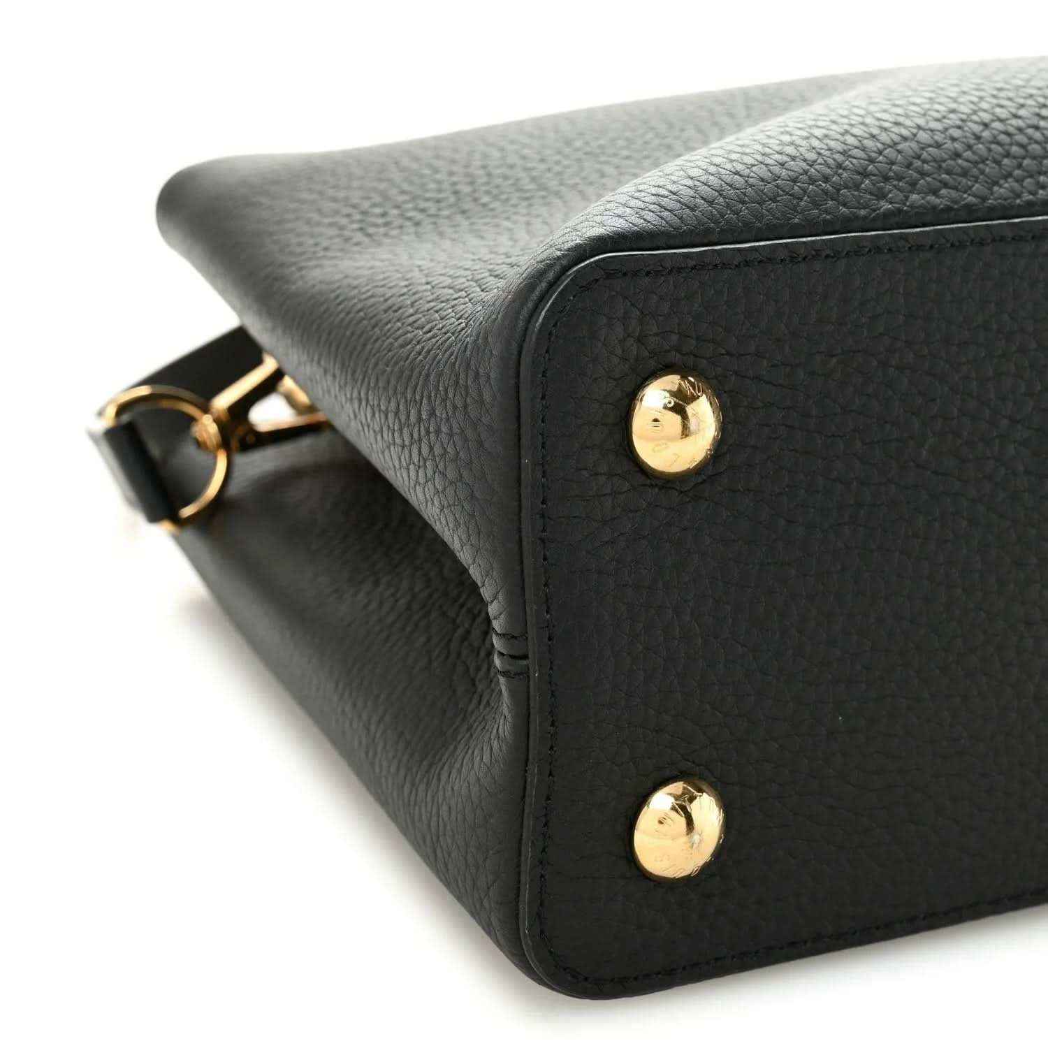 Black leather handbag corner with gold stud details and textured finish