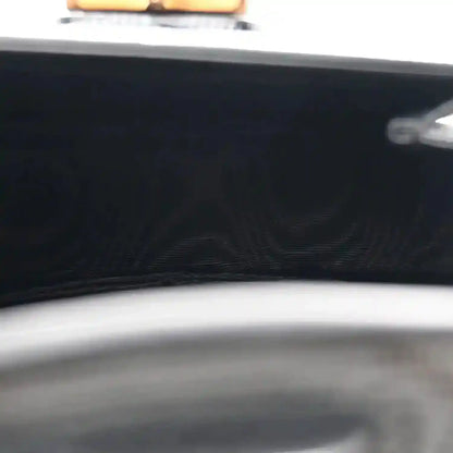 Close-up of black bag front with embossed pattern and curved top edge trim