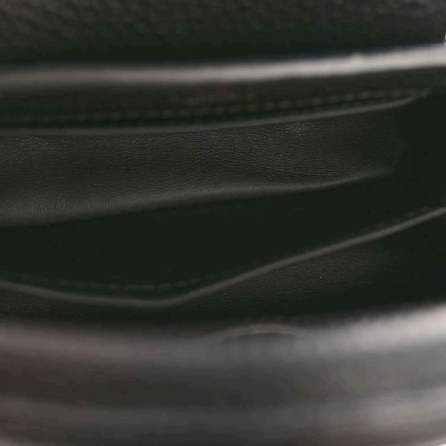 Black leather mini handbag close-up of stitched edge and interior trim