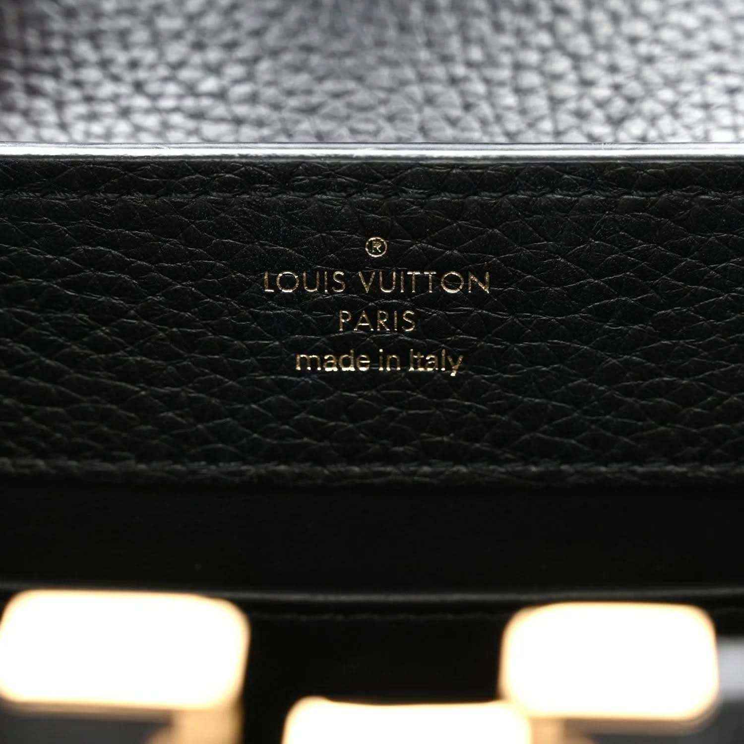 Black leather mini handbag brand label reading LOUIS VUITTON and made in Italy