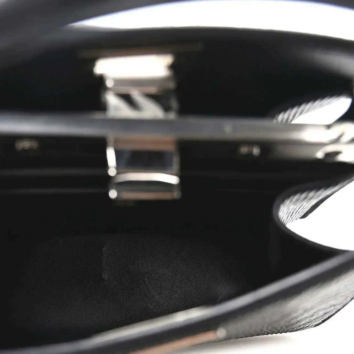 Black leather interior with engraved logo inside open satchel