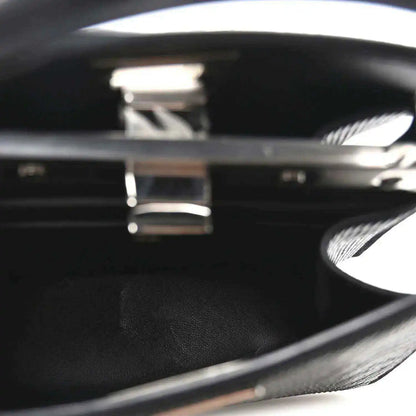 Black leather interior with engraved logo inside open satchel