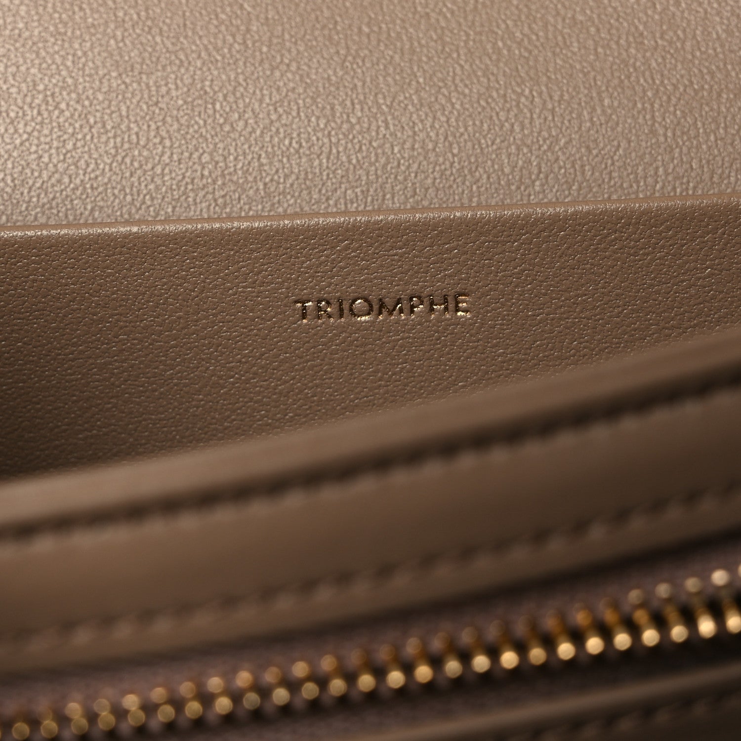 Triomphe embossed on beige leather