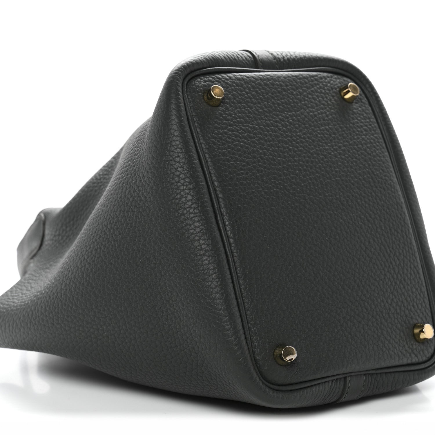 Side view of dark green textured mini bag with gold corner studs and curved base.