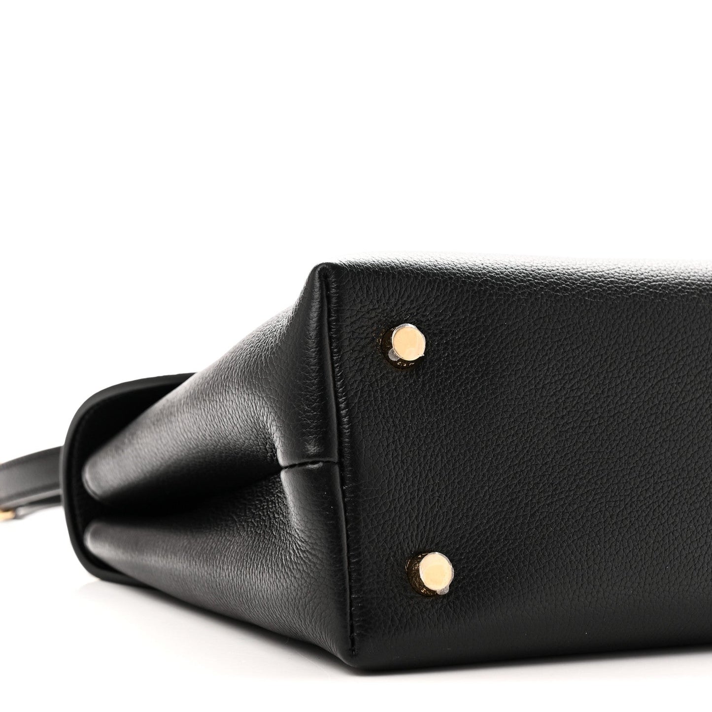 Black leather handbag side with two gold studs and curved corner seam