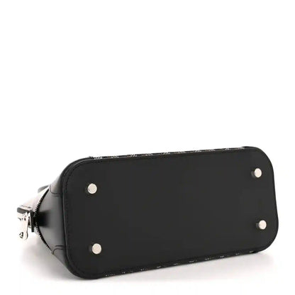 Black mini bag with silver studs on the bottom panel and curved zipper edge