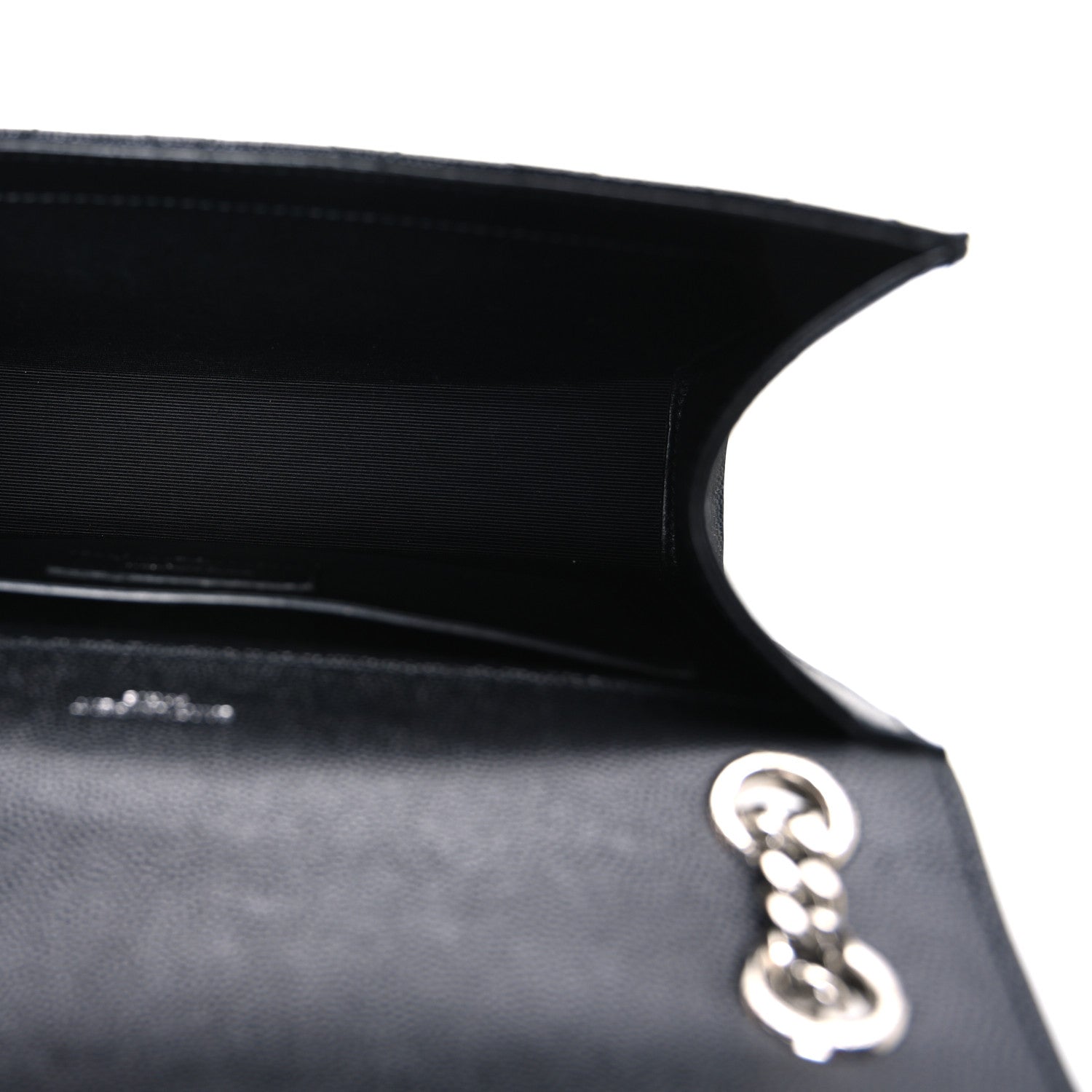 Satchel interior with black lining and silver chain hardware near the opening