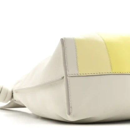 Side view of knot clutch with pale grey base, light citrine panel, and braided handle