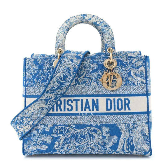 Blue embroidered tote bag with structured top, gold rings, and Dior-Paris print.
