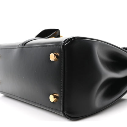 Celine mini bag close-up in black leather with round gold studs on side panel