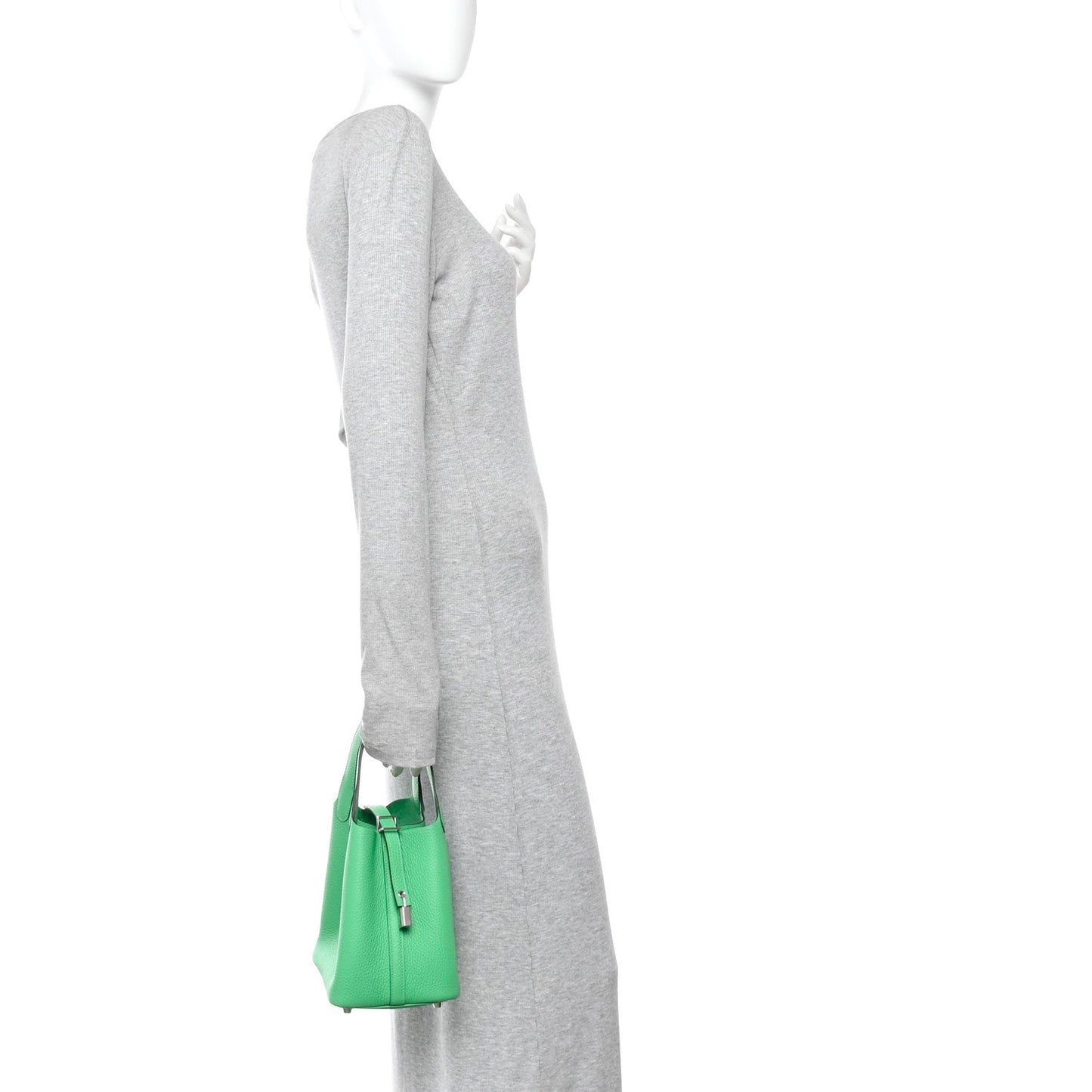 Green leather tote bag with top handles and center zipper lock, on a sleeve