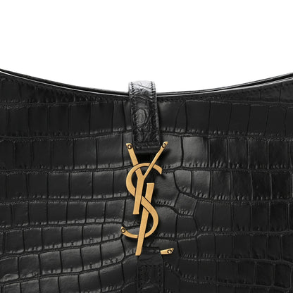Close-up of black crocodile-embossed bag front with YSL clasp hardware.