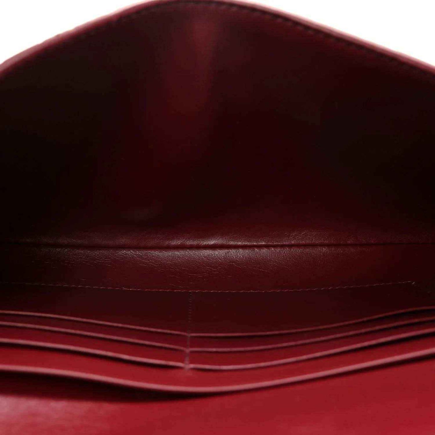 Burgundy leather clutch bag interior with stitched lining and fold seam