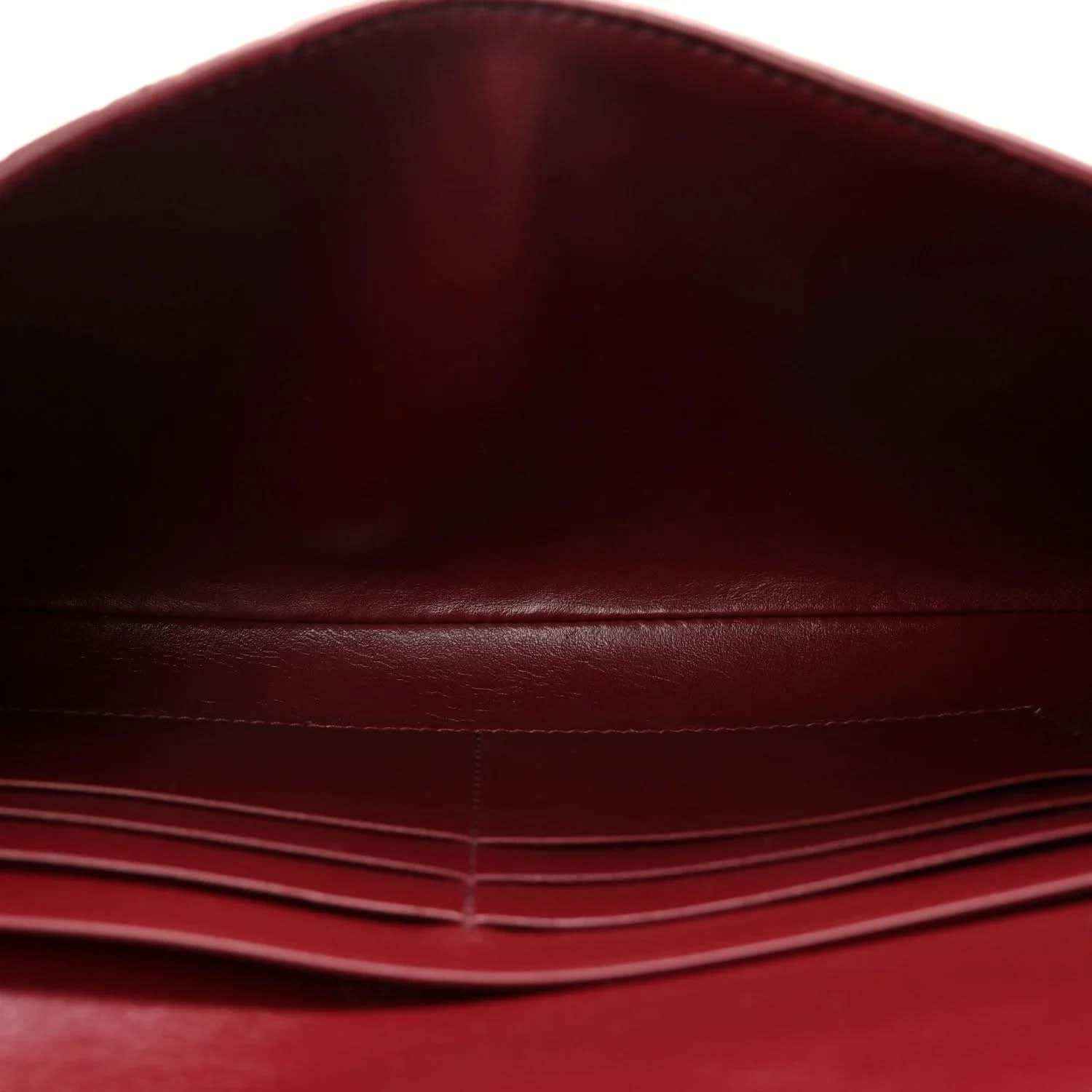 Burgundy leather clutch bag interior with stitched lining and fold seam