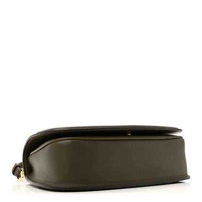 Dark green leather bag side view with smooth finish, subtle seam line, and small hardware