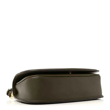 Dark green leather bag side view with smooth finish, subtle seam line, and small hardware