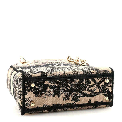 Mini embroidered handbag with top zip and gold-tone corner hardware, black-and-cream