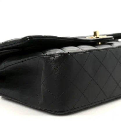 Chanel black quilted lambskin double flap bag side close-up with gold top hardware