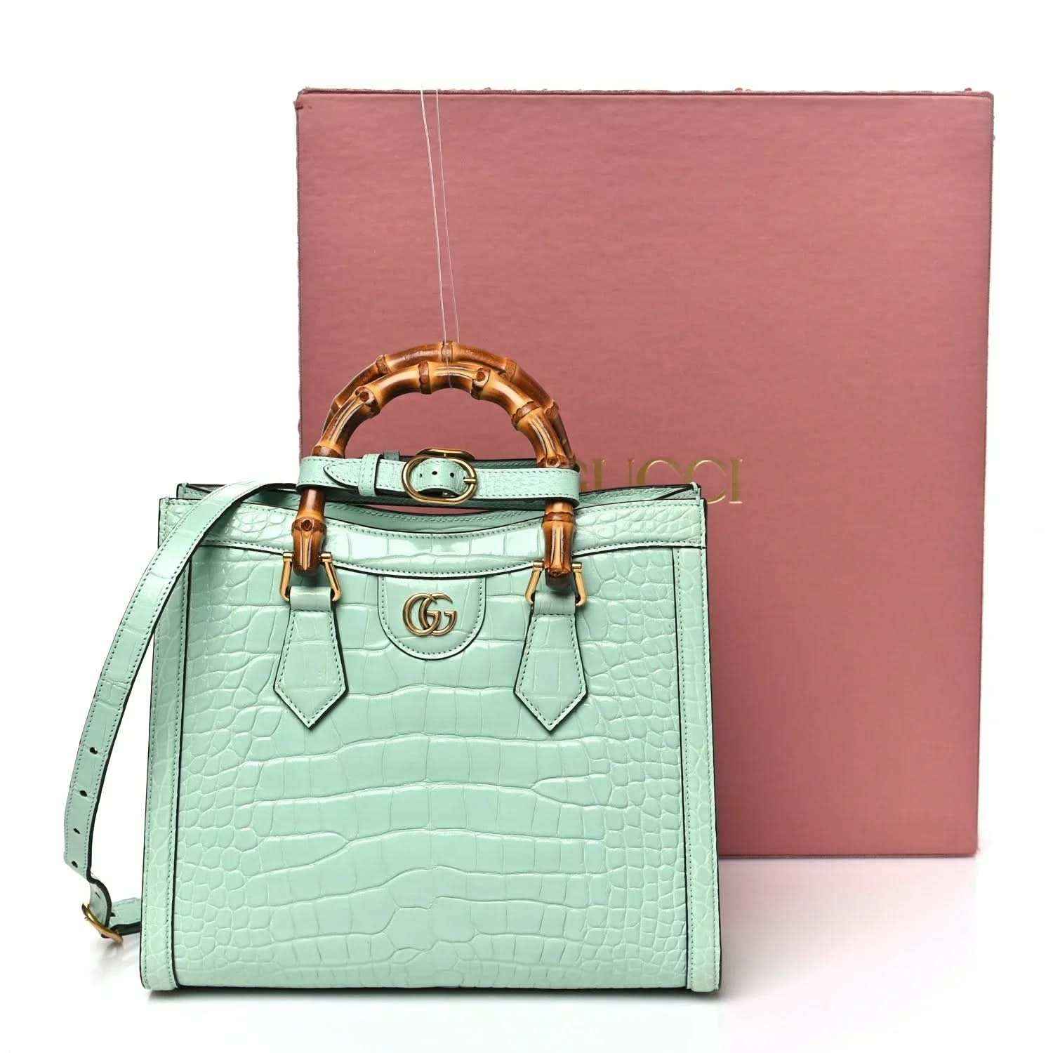 Small green tote bag with bamboo handles, front GG emblem, and leather strap charms