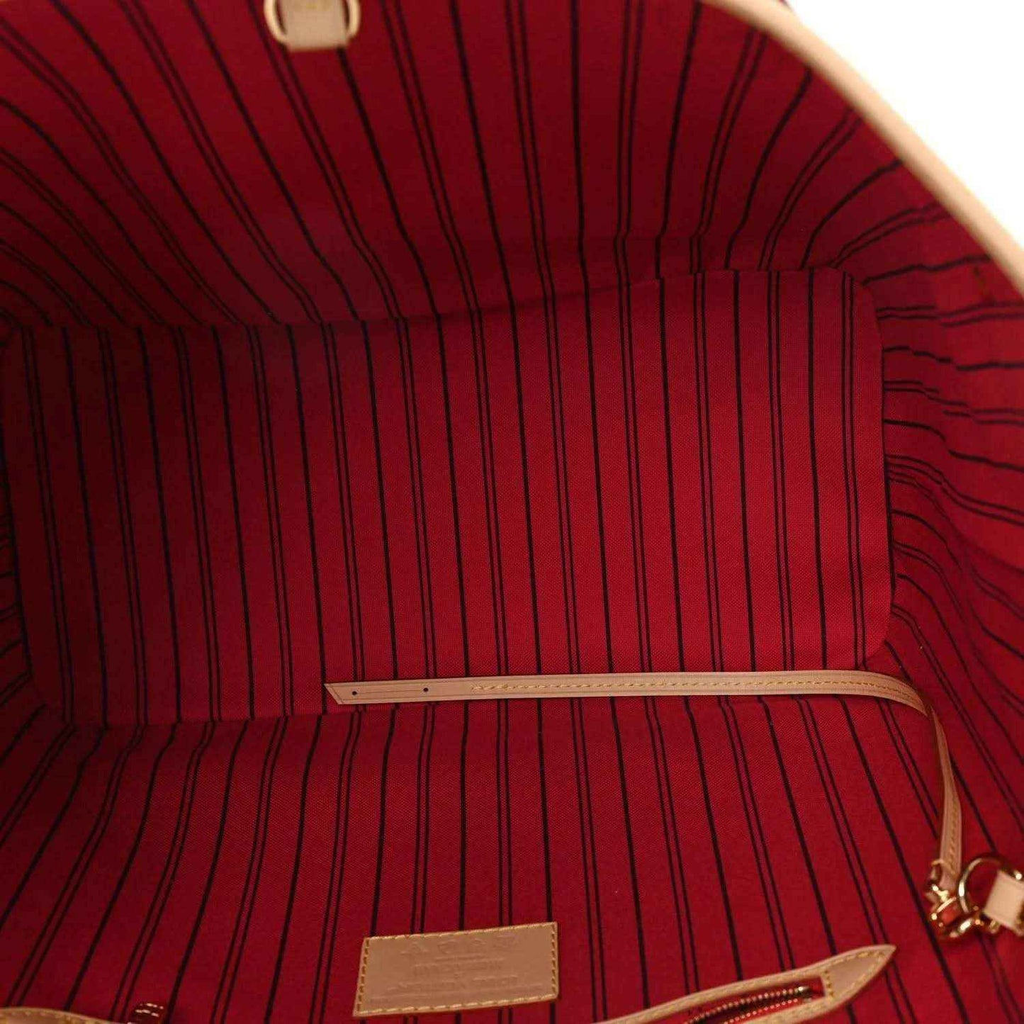 Tote bag interior with red striped lining and tan leather pocket patch.