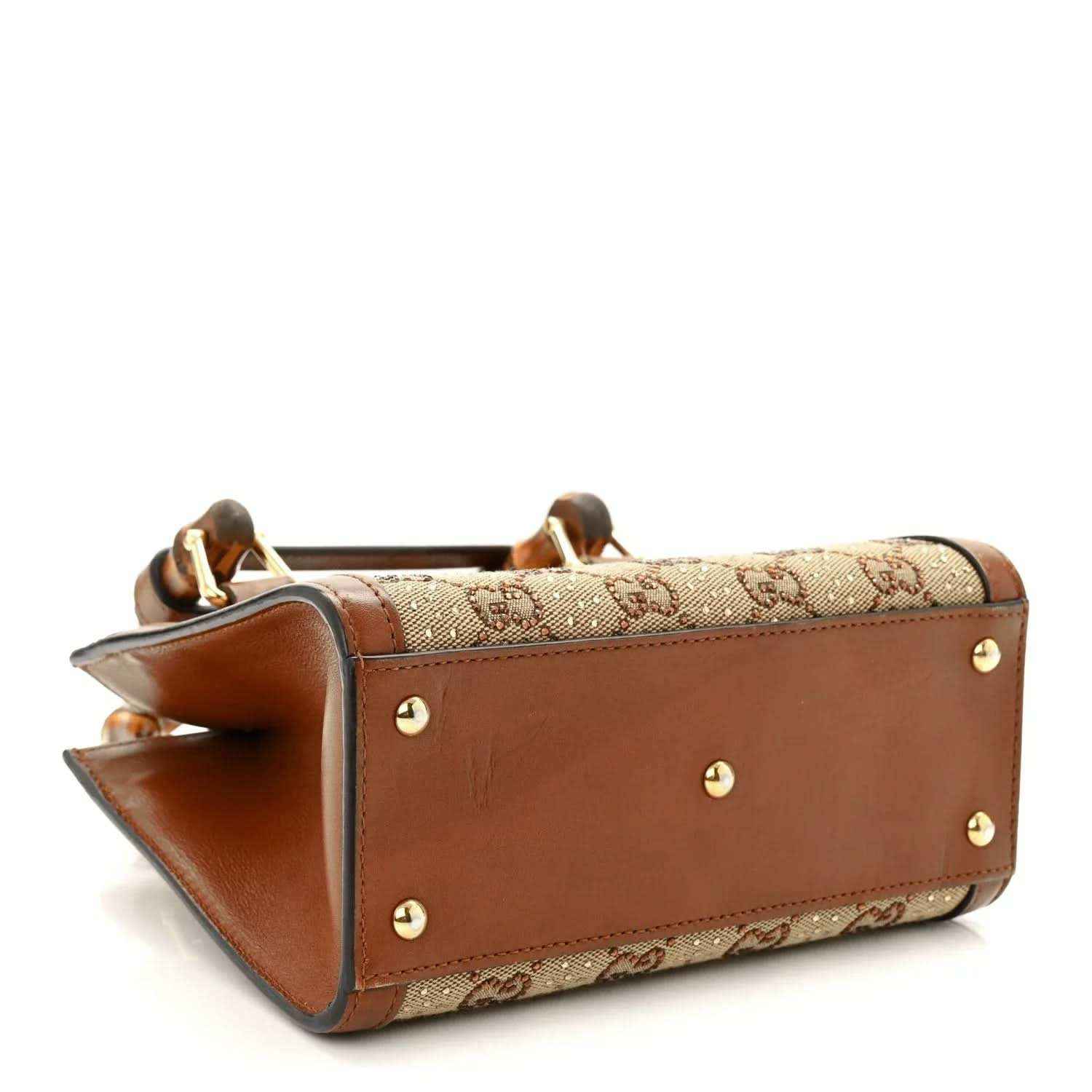 Gucci mini tote bag side view with GG canvas, brown leather base, gold-tone studs.