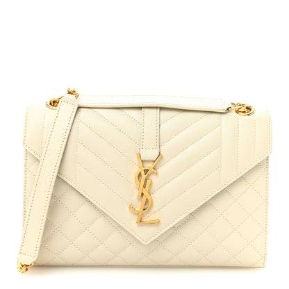 Cream quilted satchel with front monogram latch, gold hardware, and chain shoulder strap