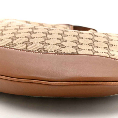Canvas top edge with stitched brown leather trim on GG monogram shoulder bag
