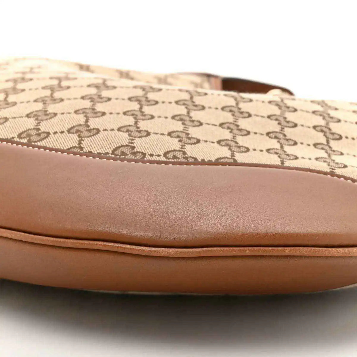 Canvas top edge with stitched brown leather trim on GG monogram shoulder bag