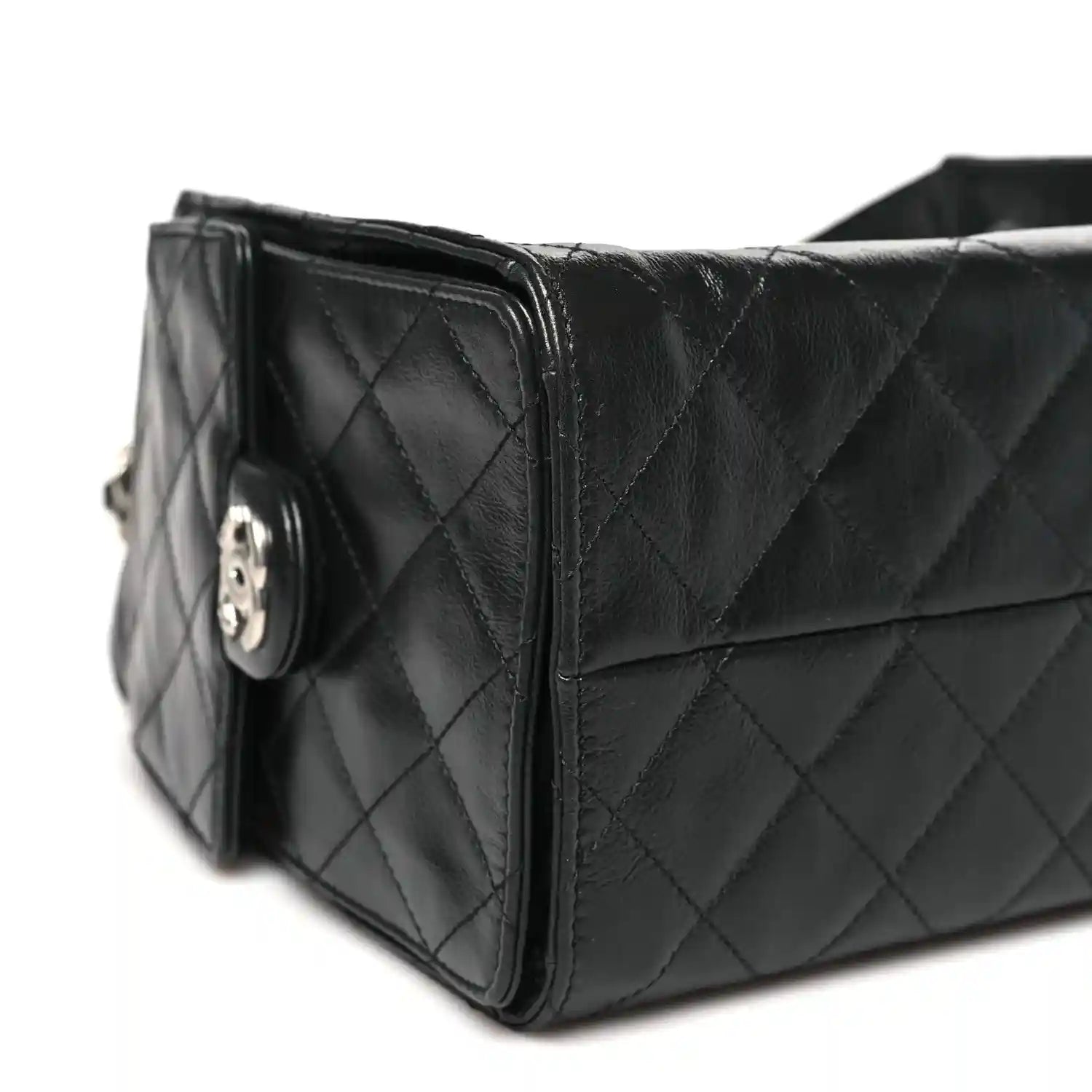 Chanel black quilted leather handbag side view with logo detail on clasp