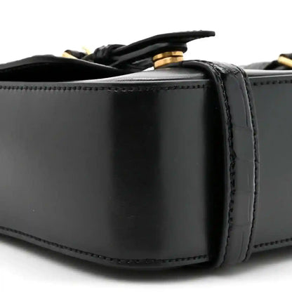 Black leather messenger bag close-up of top edge and strap attachment hardware