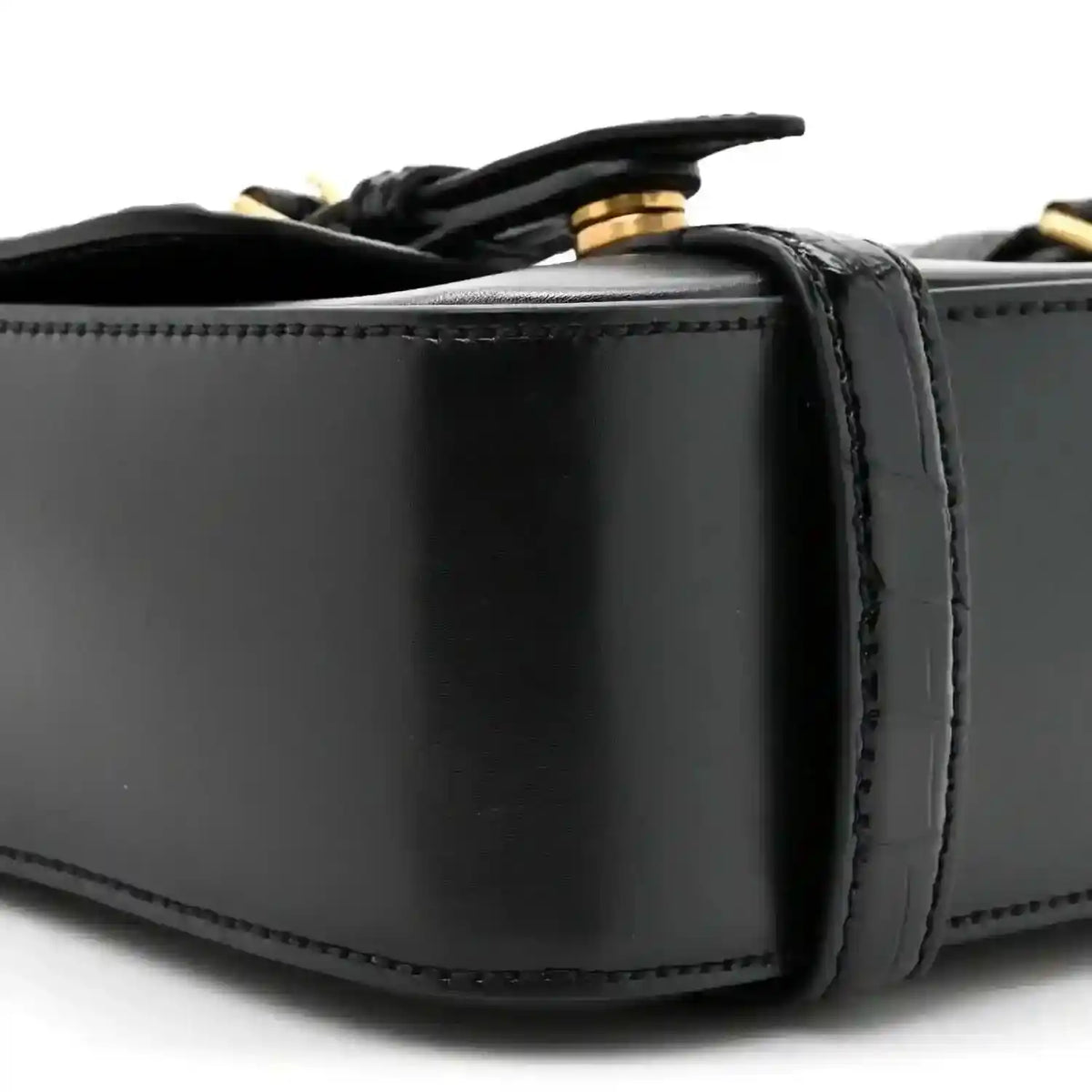 Black leather messenger bag close-up of top edge and strap attachment hardware